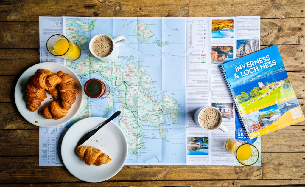 Map with croissants, coffee, orange juice and travel guide with an Inverness & Loch Ness travel guide for suggesting trip planning. 